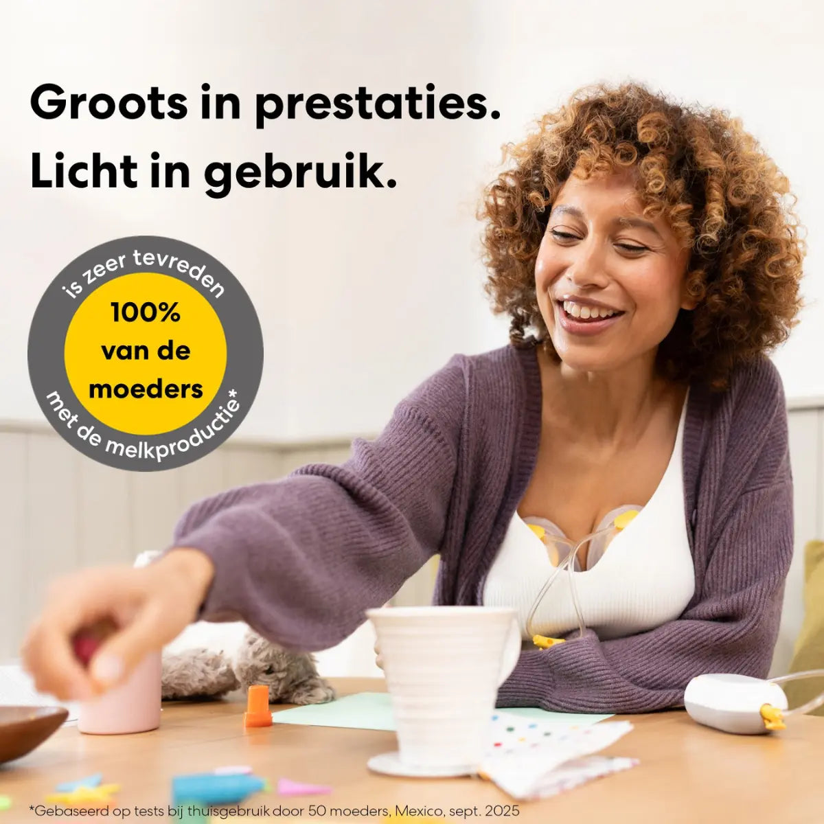 Moeder ontspant aan tafel met de lichte en krachtige Medela Freestyle Mini borstkolf.