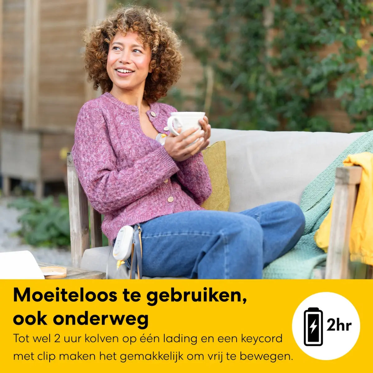 Mama gebruikt de draadloze en oplaadbare Medela Freestyle Mini kolf buiten op een bankje.